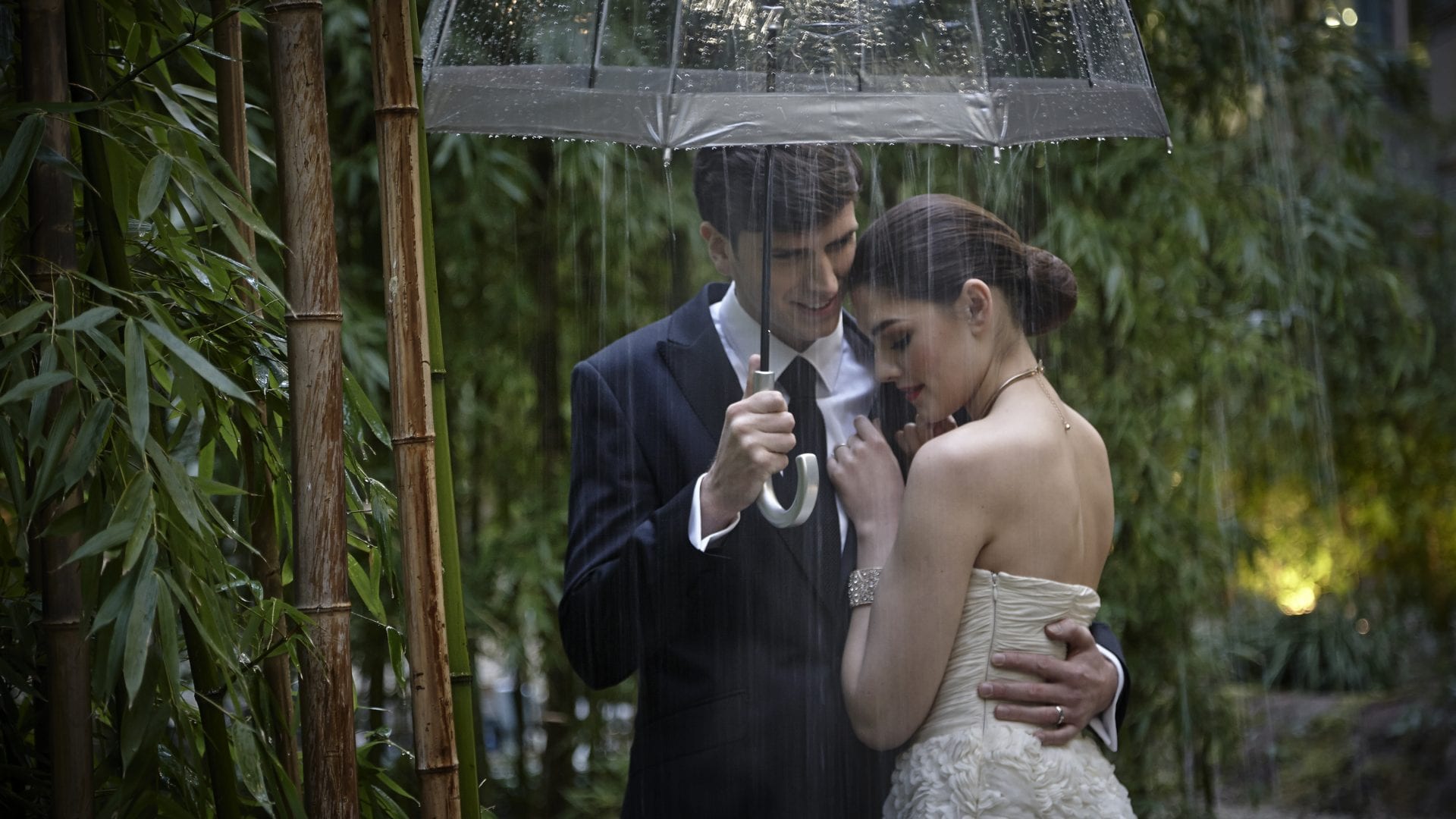 Couple in wedding attire hugging under an umbrella | small wedding venue in dublin